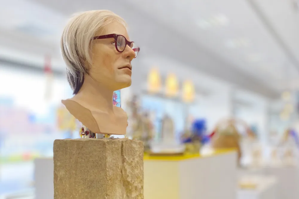 Eine Büste mit Haaren und Brille auf einem Block aus Holz